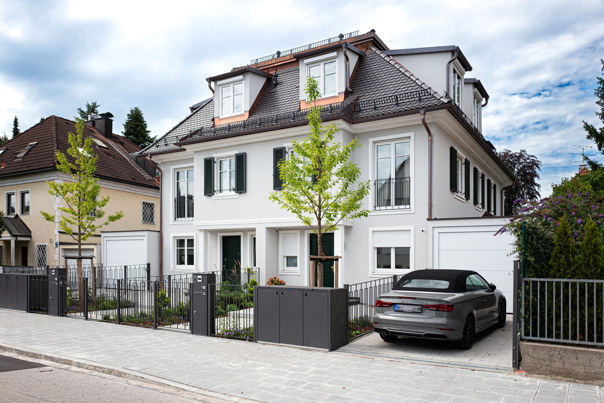 Straßenansicht eines Neubau Doppelhauses im Villenstil in München Harlaching von DOMINO Bau