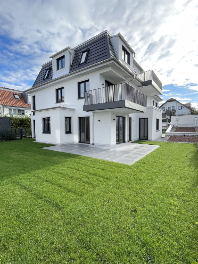 Elegant garden of a new-build apartment by DOMINO Bau in Munich-Trudering