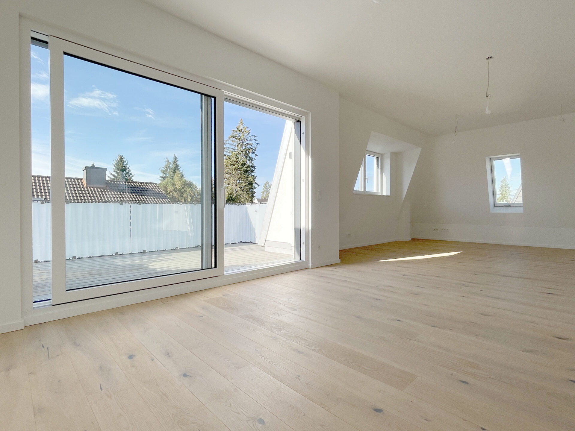 Wohn- und Esszimmer sowie Küche einer Neubau-Wohnung von DOMINO Bau in München-Trudering