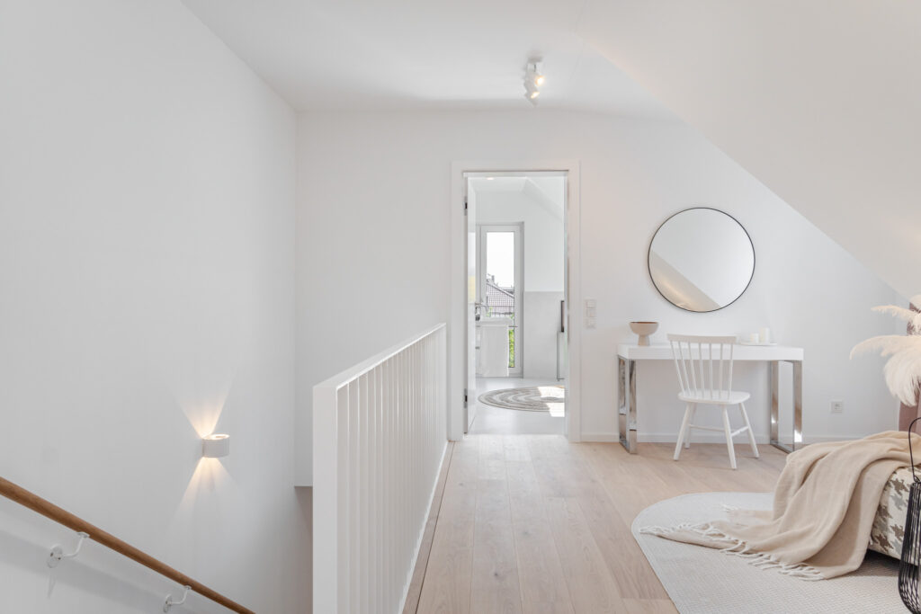 Bright dressing room on the top floor with a view of the bathroom; new semi-detached house from DOMINO Bau in Munich Obermenzing