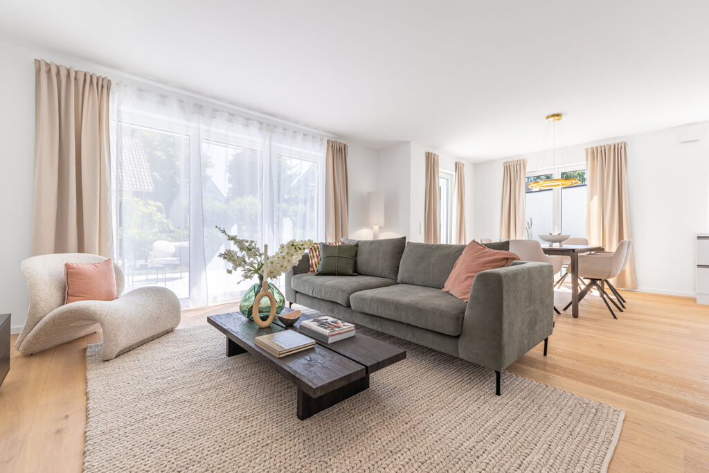 Foto eines Wohnzimmers mit Sofa und Esstisch im Neubau Doppelhaus in Garching bei München von DOMINO Bau
