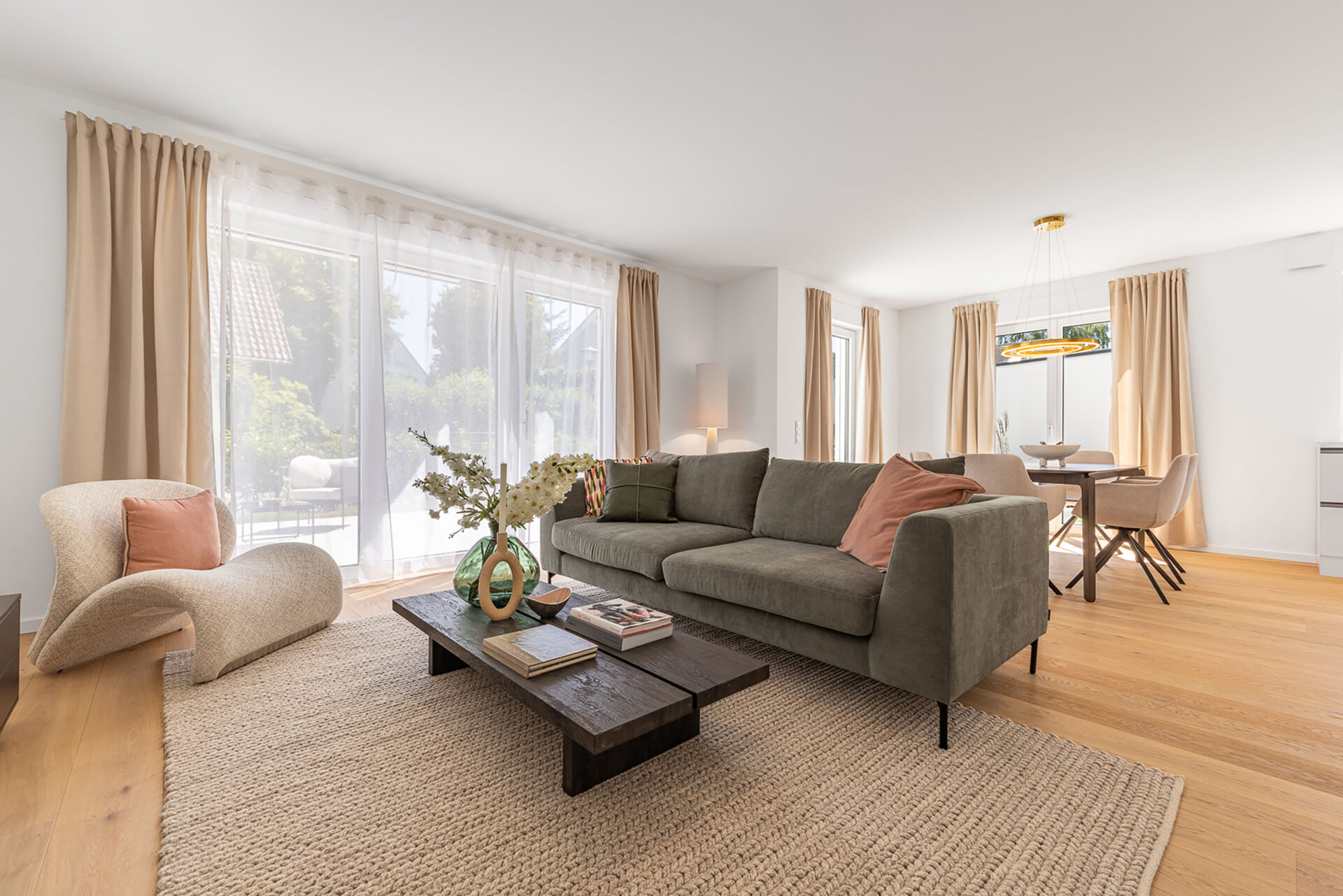 Foto eines Wohnzimmers mit Sofa und Esstisch im Neubau Doppelhaus in Garching bei München von DOMINO Bau
