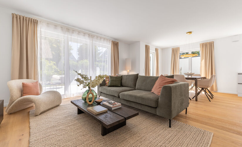 Foto eines Wohnzimmers mit Sofa und Esstisch im Neubau Doppelhaus in Garching bei München von DOMINO Bau