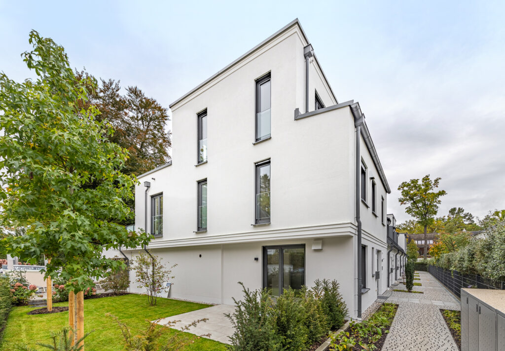 Sicht von der Straße auf sechs Stadthäuser von DOMINO Bau in Obermenzing