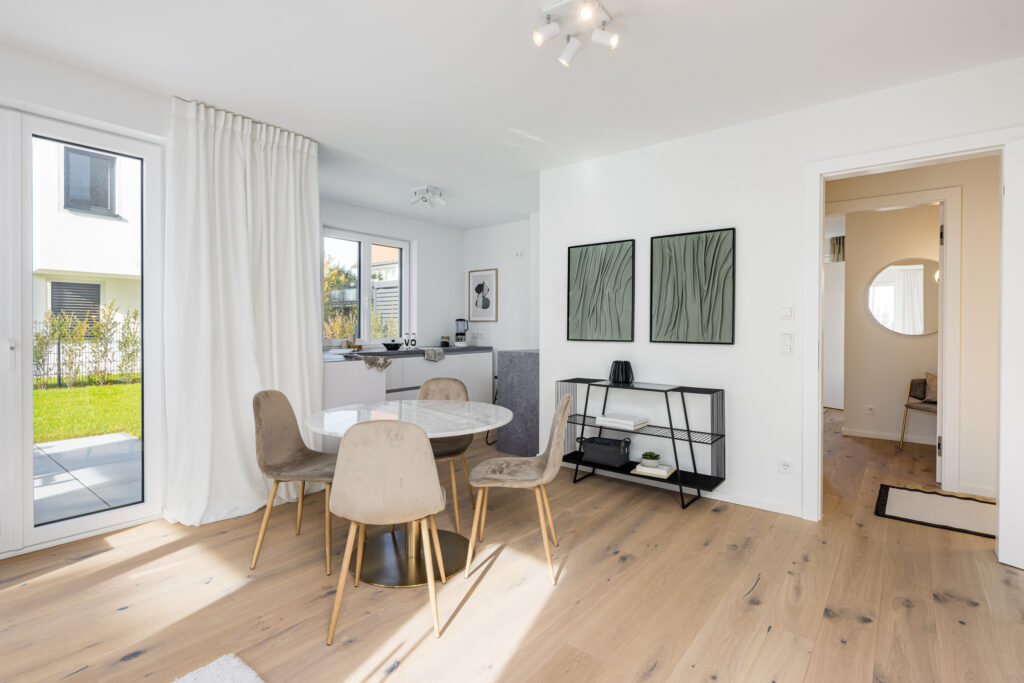 Foto eines Wohnzimmers mit Küche im Erdgeschoss einer bezugsfertigen Neubauwohnung in Trudering von Domino Bau