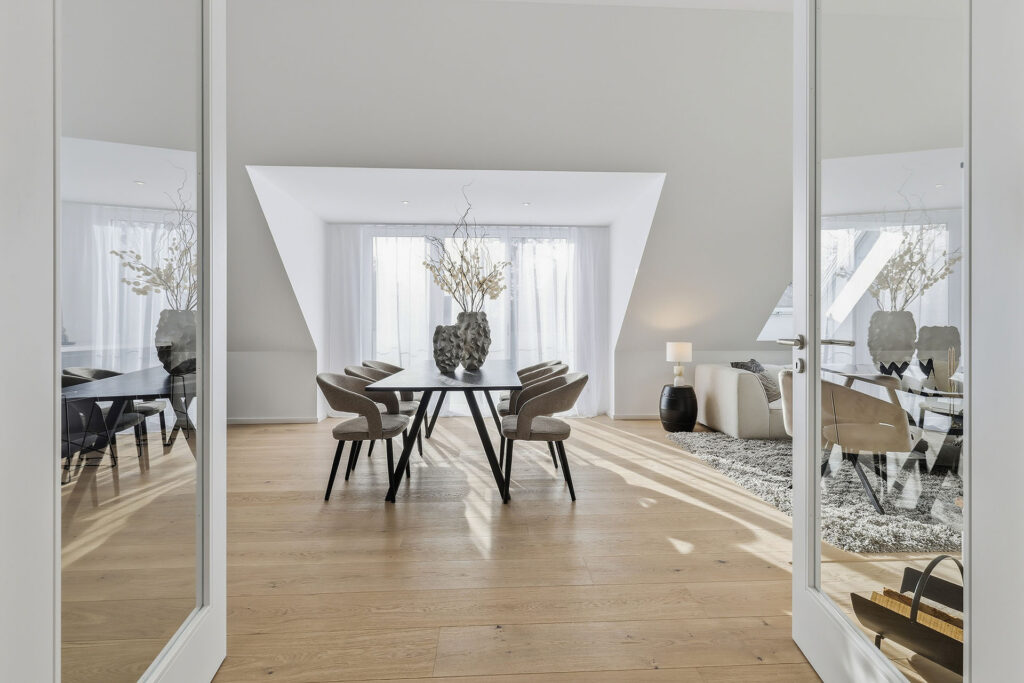Photo of a living-dining area in the attic of a multi-family house with three apartments by DOMINO Bau in Munich Solln