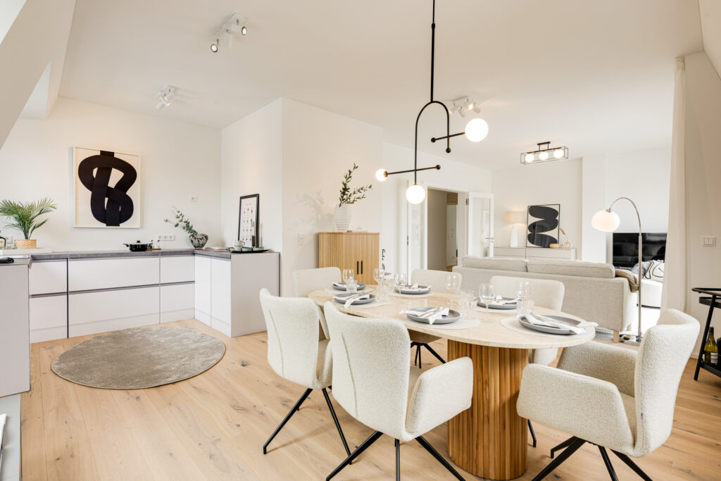 Photo of a living room with a kitchen and dining table in the attic of a move-in-ready new-construction apartment in Trudering by Domino Bau